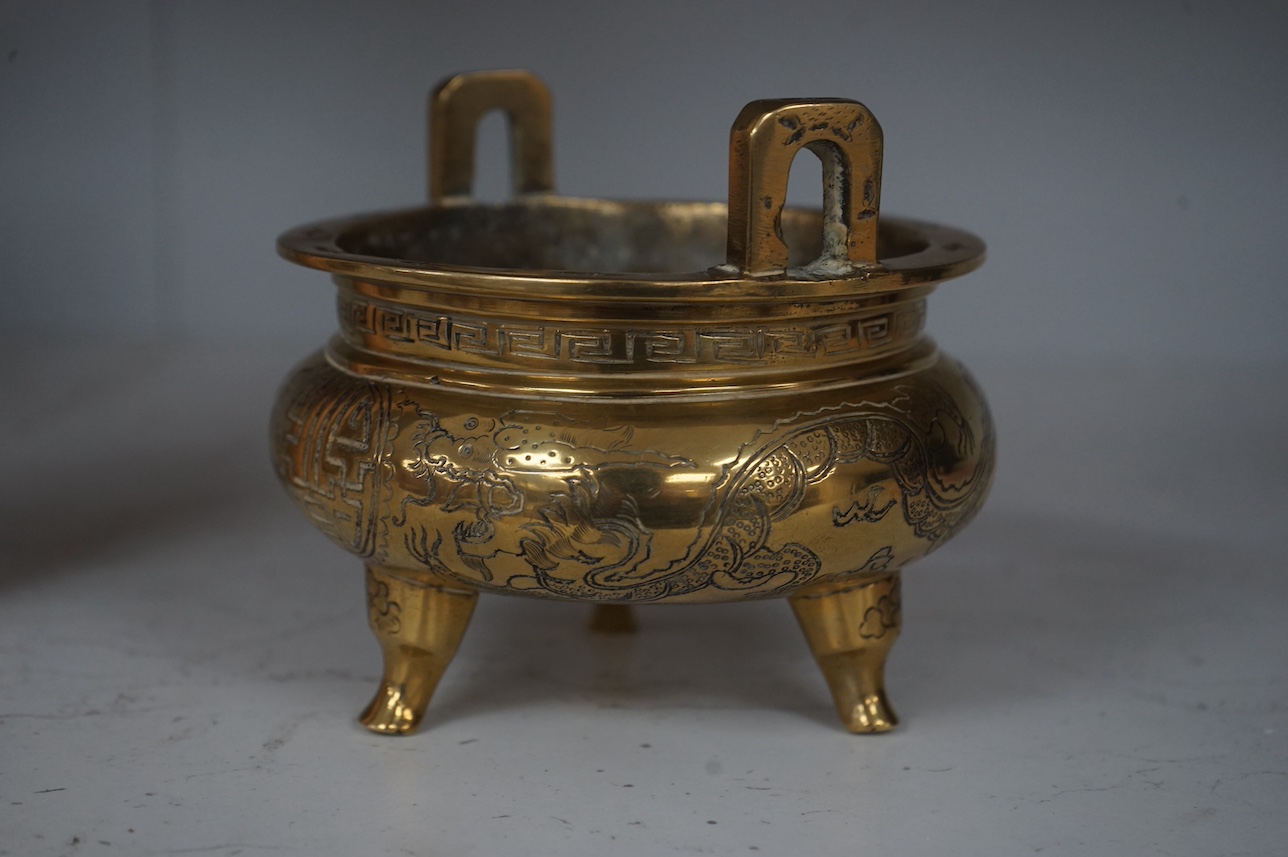 A Chinese engraved and chased bronze tripod censer, Xuande mark, early 20th century, 10.5cm. Condition - good